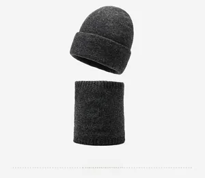 Detailed knit texture of dark gray winter beanie and neck gaiter set with leather label