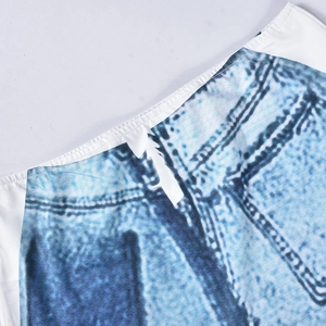 Detail showing elastic waistband and denim-print fabric stitching on the skirt