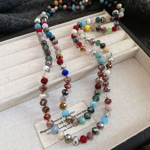 Detail of colorful faceted crystal beads displayed on beige velvet in a jewelry box