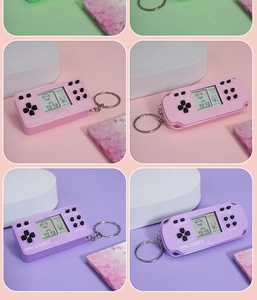 Dettaglio dei portachiavi mini console per videogiochi portatile rosa e viola con LCD