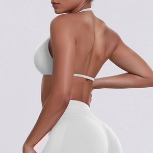 Detail of white seamless halter sports bra and high waist leggings on a fit model