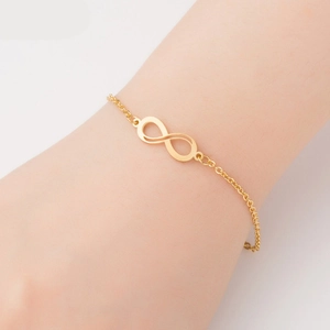 Detail of golden infinity symbol titanium steel bracelet worn on a female wrist