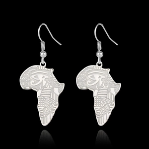 Détail macro de boucles d'oreilles carte d'Afrique argentées avec gravures Horus
