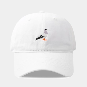 Dettaglio del cappellino in cotone bianco con ricamo a piccione e visiera curva