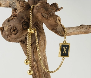 Vue détaillée du bracelet chaîne à mailles carrées dorées avec pendentif lettre X