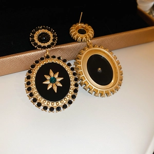 Macro view of vintage baroque gold earrings with green gemstones and star motifs
