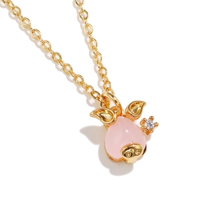 Macro shot of 18K gold plated pig pendant featuring pink stone and zircon detail