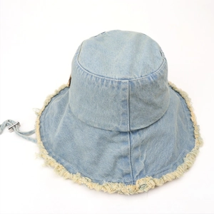 Detail view of denim bucket hat with frayed edges and adjustable windproof strap