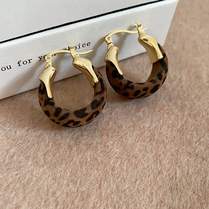 Close-up of vintage U-shaped earrings with gold metal and leopard print flocking texture
