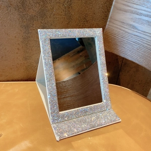 Detail shot of the folding makeup mirror featuring sparkly silver rhinestones on the frame