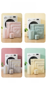 Detail of four candy-colored fine mesh laundry bags in pink, green, grey, and yellow