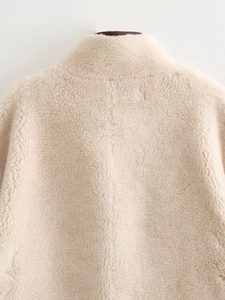Close-up of the thick, curly beige faux fur texture on the collar and shoulder area