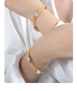 Close-up of gold snake texture bracelets with micro-pave zircon cylindrical charms