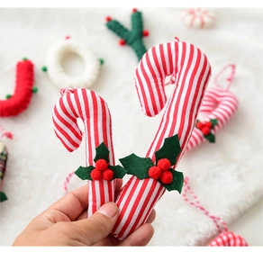 Detail of fabric candy cane ornaments with red stripes, holly leaves and berries