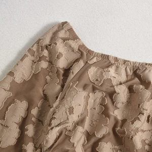 Détail du tissu jacquard floral 3D avec taille élastique sur une robe à manches longues
