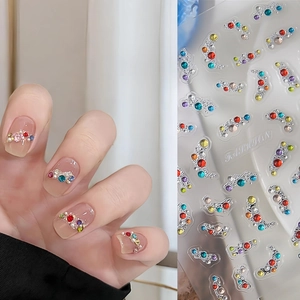 Close-up of colorful rhinestone nail stickers with pearls and jelly crystal finish
