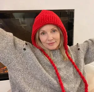 Détail d'un bonnet monstre rouge en maille épaisse avec de longues tresses et pompons