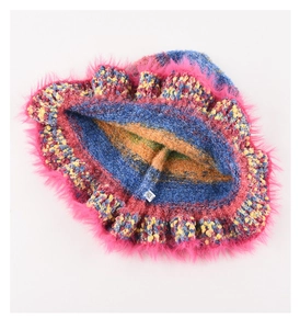 Close-up of rainbow knit bucket hat with plush pink faux fur trim and interior label