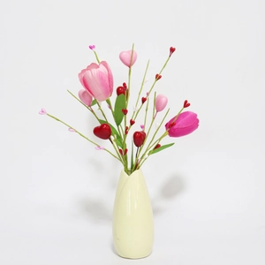Detail of pink silk tulips and heart picks in a round cream ceramic vase