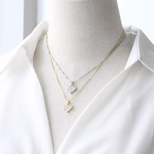 Gold and silver heart pendant necklaces with zircons on a white display stand