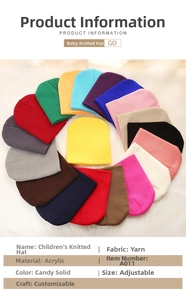 Flat lay of colorful knitted beanies for kids on a soft white faux fur background