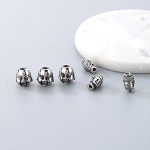 Macro view of six stainless steel Buddha head spacer beads for DIY jewelry making