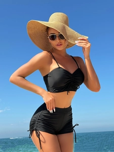 Detail showing high-waisted bikini shorts with adjustable side drawstrings and ruching