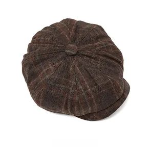 Top view detail of retro wool blend newsboy cap with brown plaid pattern and top button