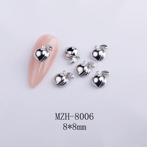 Macro view of 8x8mm silver metal heart peach nail art charms on a pink nail tip