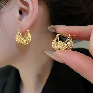 Detailed view of hollow flower gold plated earrings showing intricate metal craftsmanship