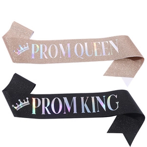 Close-up of glittery Prom King and Queen sashes with elegant crown and silver lettering