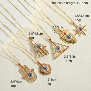 Bohemian gold necklaces with sun, heart and Hamsa evil eye pendants on stone background