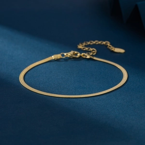 Elegant gold S925 sterling silver flat snake blade chain bracelet on a dark blue background