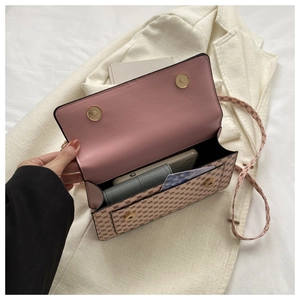 Detail of the open beige crossbody bag showing pink leather interior and magnetic buckles
