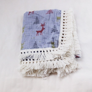 Close-up of double-layer cotton baby blanket with reindeer prints and white tassels