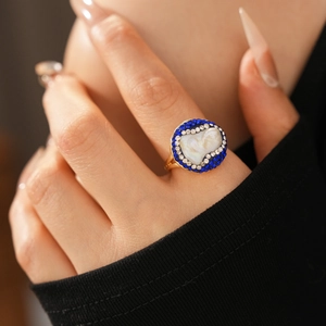 Detail of vintage gold plated ring featuring baroque pearl and blue-white rhinestones