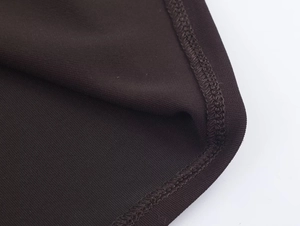 Detail view of high-density brown knit fabric showing precision double-needle stitching