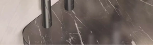 Macro detail of the dark grey marble texture on the wall-mounted toothbrush rack surface
