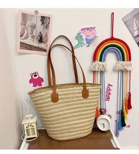 Detailed shot of striped straw tote bag featuring brown leather handles and woven texture