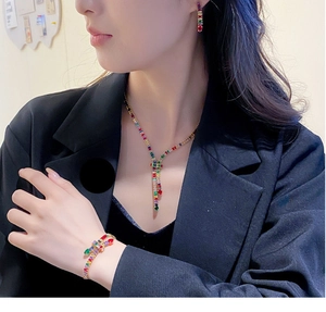 Detail of luxury gold plated jewelry set with colorful zircon stones on a female model