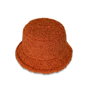 Gros plan sur la texture épaisse en laine peluche caramel d'un chapeau cloche à bord large