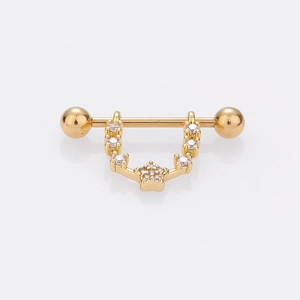 Détail de piercing téton doré avec pendentif étoile et pierres en zircone brillant
