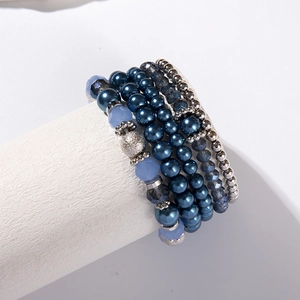 Dettaglio del set di braccialetti elastici multistrato con cristalli blu e perle finte