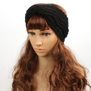 Detail view of the black cable knit winter headband with a stylish crossover twist knot