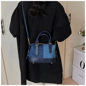 Vista posteriore di una borsa Boston in denim indossata da una modella in interno