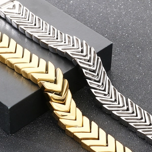 Detailed close-up of gold and silver V-shaped arrow link bracelets in polished stainless steel