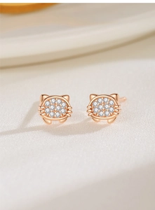 Macro shot of rose gold cat ear studs featuring full zircon micro-pave setting on satin
