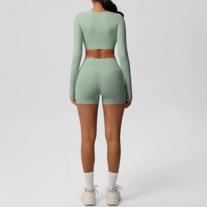 Detail showing high-waisted shorts and long sleeve crop top in sage green knit