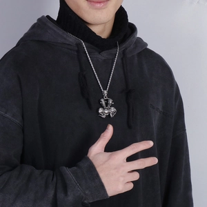 Silver stainless steel V-twin motorcycle engine pendant worn by male model on twist chain