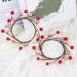 Red white and gold Christmas berry candle wreath rings on a white plush rug decoration